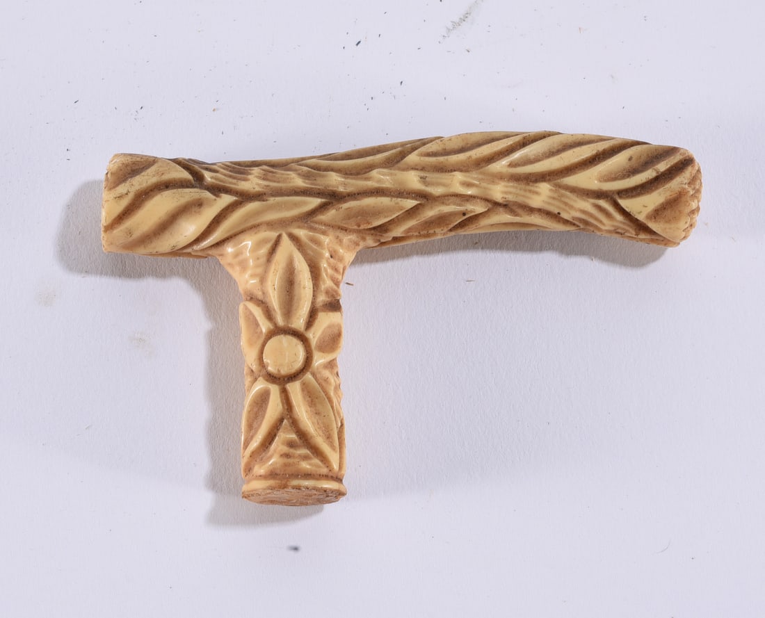 Vintage Carved Floral Cane or Walking Stick Handle: 4"x3" Vintage carved cane or walking-stick handle with T-shaped form and raised floral and foliate decoration throughout. Finished in a warm ivory-colored material with darker coloration settled into 