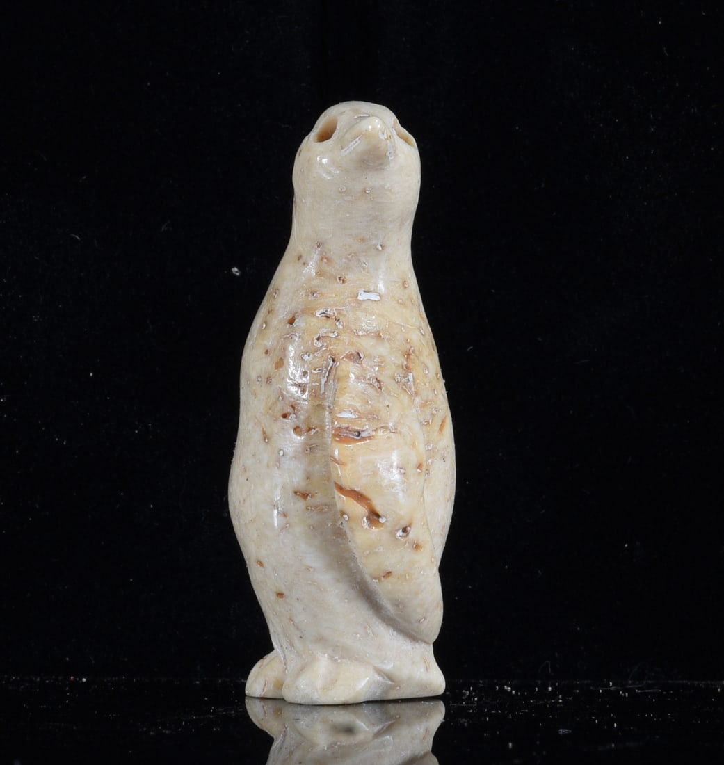 Inuit Carved Bone Standing Seal Figure: 2" Inuit carved bone standing seal figure with elongated upright body and flippers held close to the sides. Hand carved and polished with natural cream coloration and scattered porous areas throughout