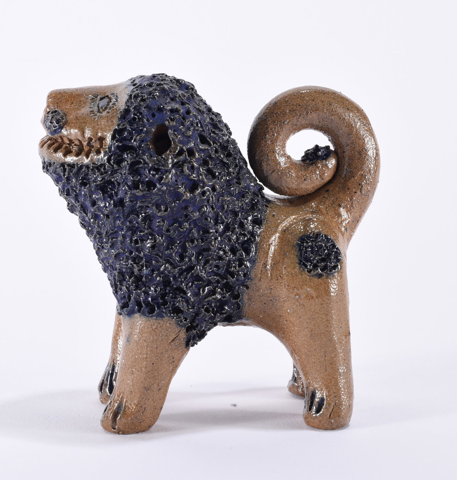 Billy Ray Hussey Miniature Salt Glaze Lion: Billy Ray Hussey miniature North Carolina folk pottery lion with four-legged body, tightly curled tail and extensively textured mane highlighted by dark blue-black glaze. The natural brown stoneware