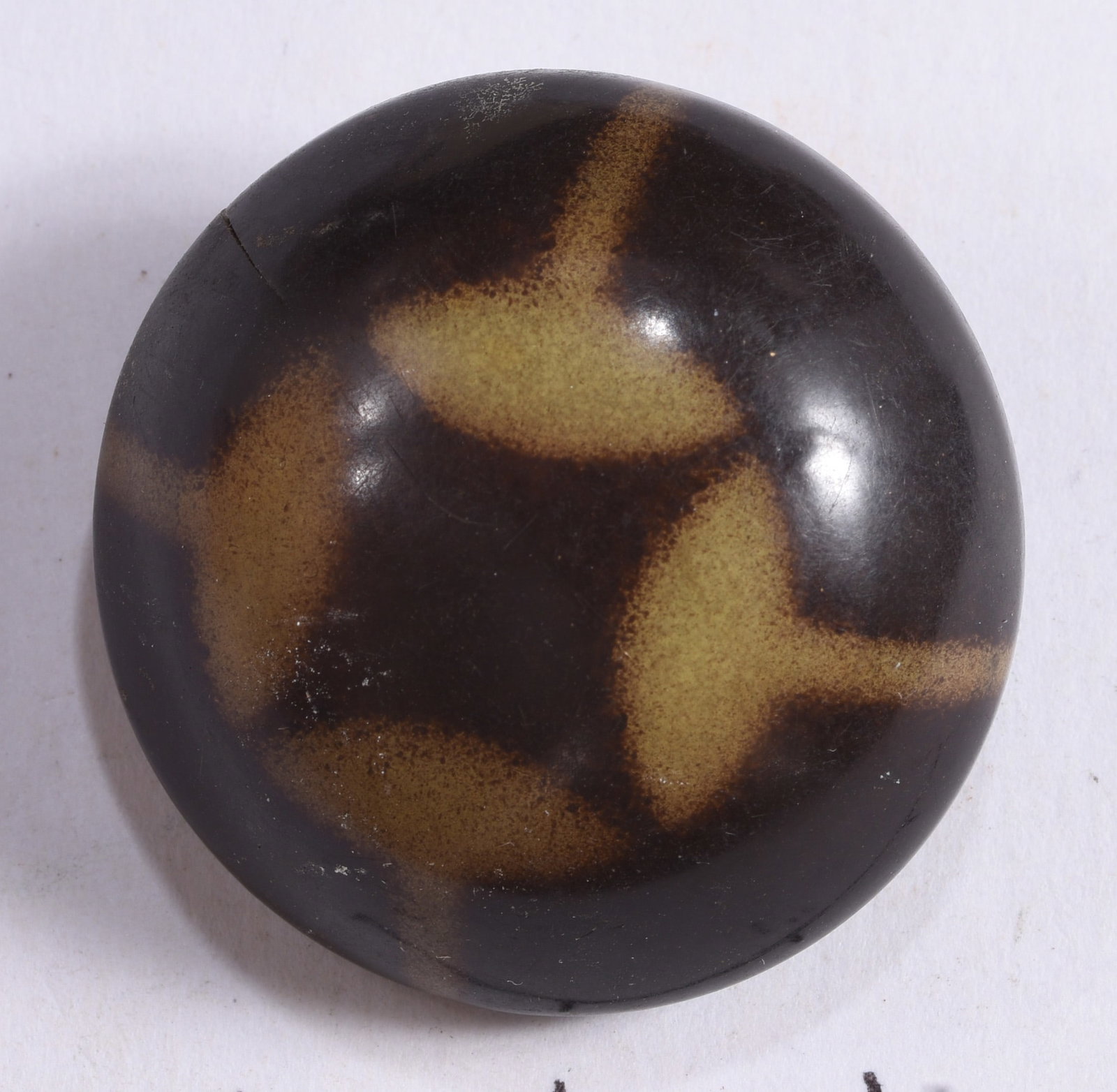 Large Antique Dark Brown Domed Composition Button: Large antique domed dark brown composition button featuring contrasting tan abstract decoration across the face. Bold rounded form with polished surface and visible age-related wear.