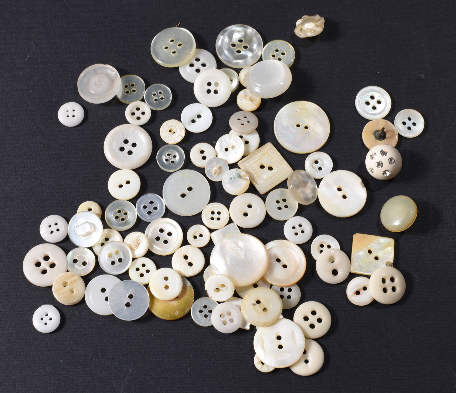 Collection of White Mother-of-Pearl & Shell Buttons: Large collection of vintage white and cream mother-of-pearl and shell buttons in assorted sizes and forms. Includes two-hole, four-hole and shank examples together with round, square and carved decora