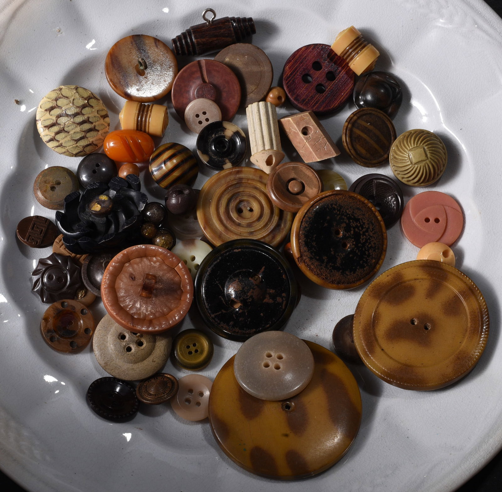 Collection of Vintage Decorative Brown & Amber Buttons: Collection of vintage decorative buttons in brown, amber, black and tan tones. Includes oversized coat buttons, molded geometric designs, striped examples, carved-look surfaces and unusual cylindrical