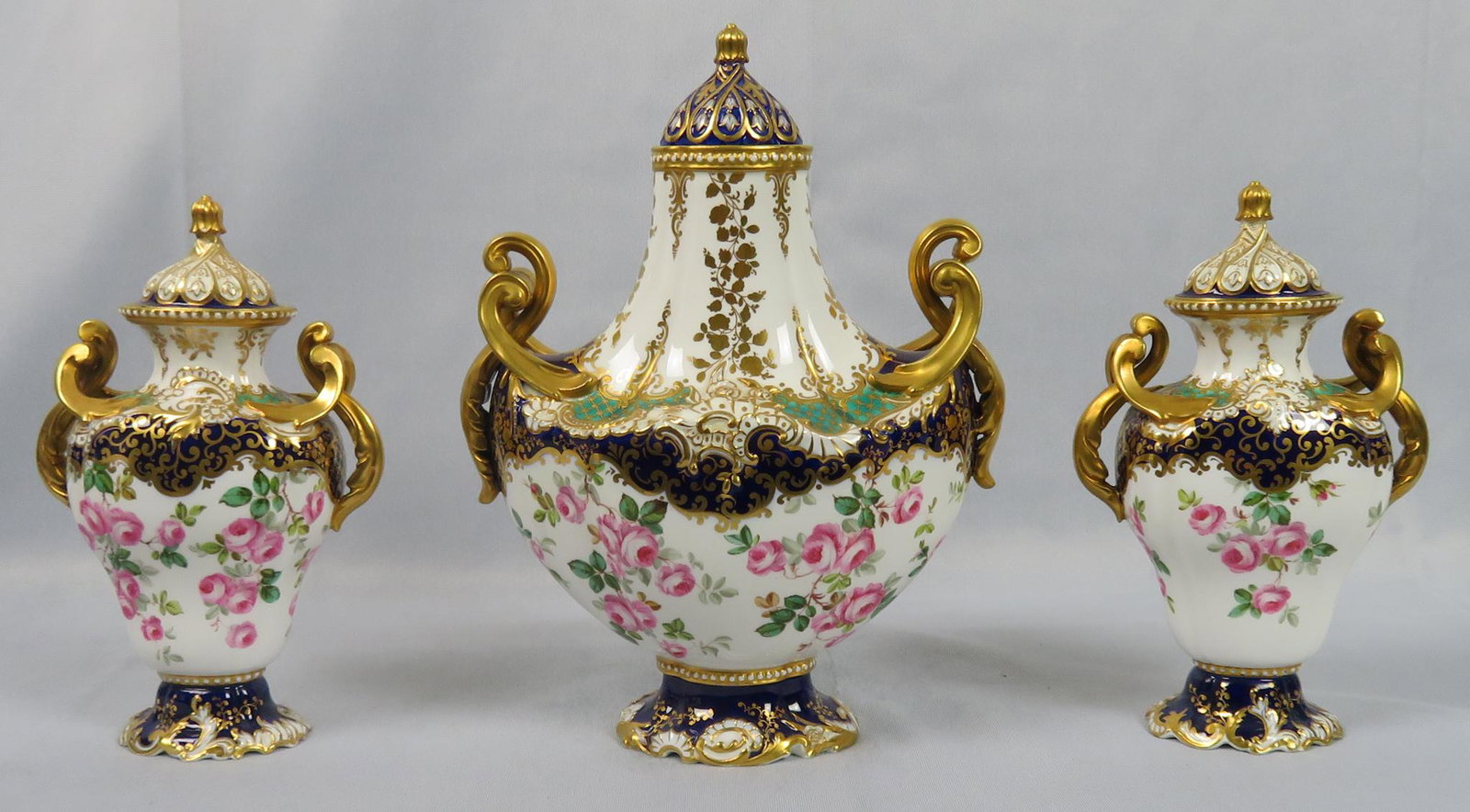 19th Century Copeland Spode Gilt Porcelain Garniture: Maker: Copeland China Location of Manufacture: England Retailer: T. Goode & Co. (London) Period: 1890 - 1910 (possibly earlier) Material: Porcelain Dimensions of Central Urn: 10 1/2"(h) x 8"(w) x 4 1/