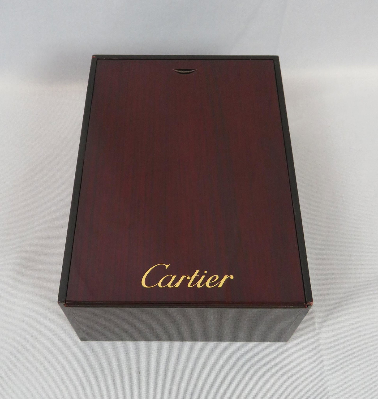 Cartier Lacquered Rosewood Watch Jewelry Display Box: Maker: Cartier Material: Rosewood Dimensions: 8 (l) x 6"(w) x 3 1/2'(h)Weight: 1 lbs. 1 oz. For your consideration is a Cartier lacquered rosewood display box. The box lid slides off to reveal a compa