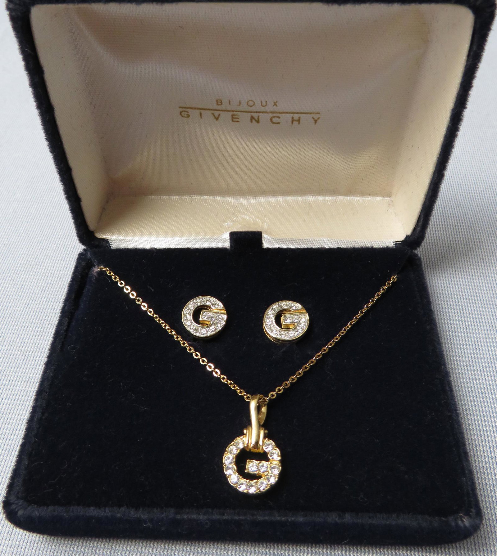 Rhinestone Givenchy Logo Stud Earrings & Necklace NIB: Manufacturer: Givenchy Location of Manufacture: France Period of Manufacture: 1990's Materials: High Quality Rhinestones & Gold Plate Dimensions of Pendant: 1/2" square Length of Chain: 16" Dimensions