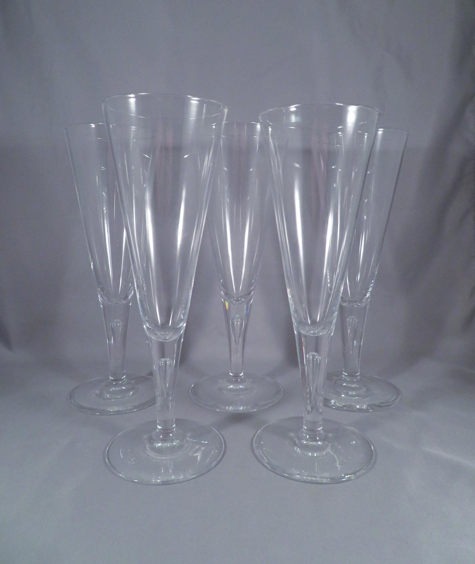 (5) Steuben Glass Teardrop 7924 Champagne Flute Glasses: Manufacturer: Steuben Glass Location of Manufacture: Corning, New York Period of Manufacture: mid-20th Century Dimensions (each): 8"(h)Weight of Lot: 1 lbs. 15 oz. For your consideration are (4) teard