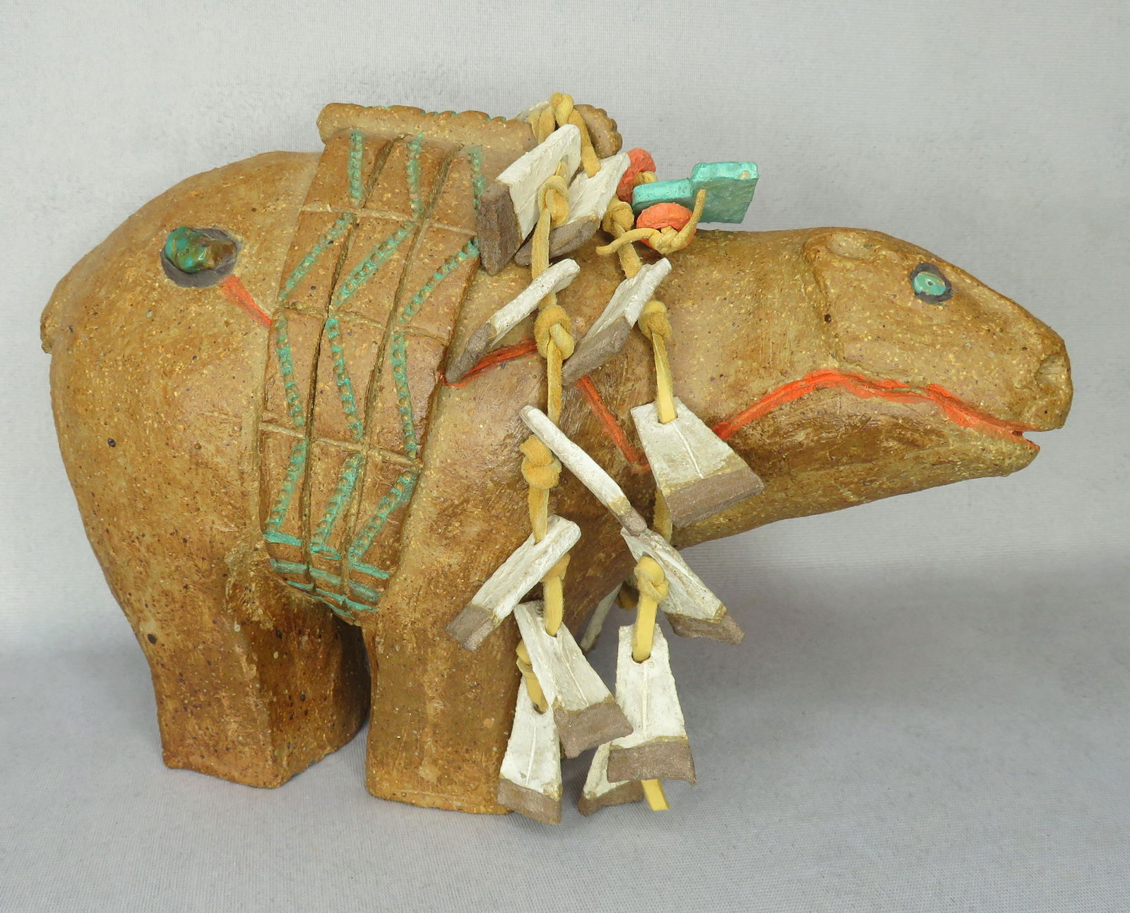 Agnes C. Sims Pottery Bear Fetish Figure: Artist: Agnes Sims (1910-1990)Untitled (Bear Fetish Figure) Materials: Terracotta, Stoneware, Pigment, Turquoise, Leather & Feather Dimensions: 11"(l) x 7"(h) x 5"(w) Weight: 6 lbs. 12 oz. For your co