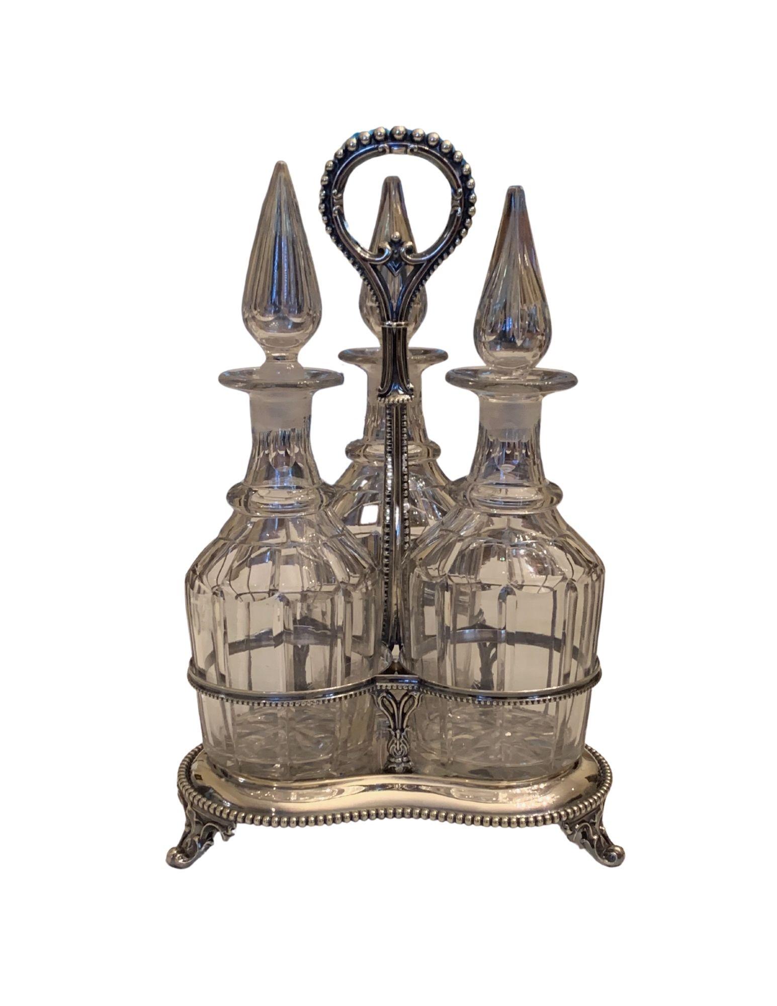 Georgian Decanter Set with Silver Plated Frame, Circa 1860: A Trio-Georgian Decanter Set with Silver Plated Frame, Sheffield mark on base, Original Stoppers, Circa 1860, 16 ½” High