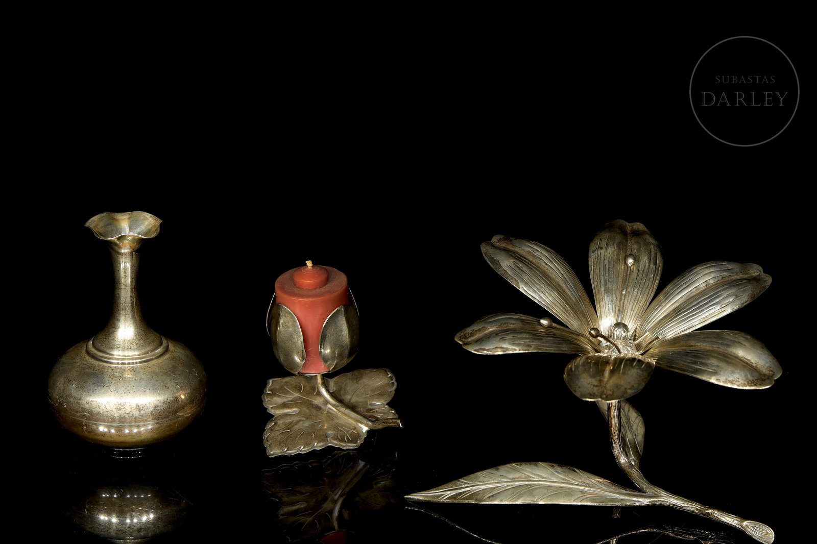 Three silver decorative objects, 20th century: Three decorative objects in 925 sterling silver. The first is a small vase with a rounded body and a long mouth, the second a leaf-shaped holder for a candle, and the third a flowering branch with det