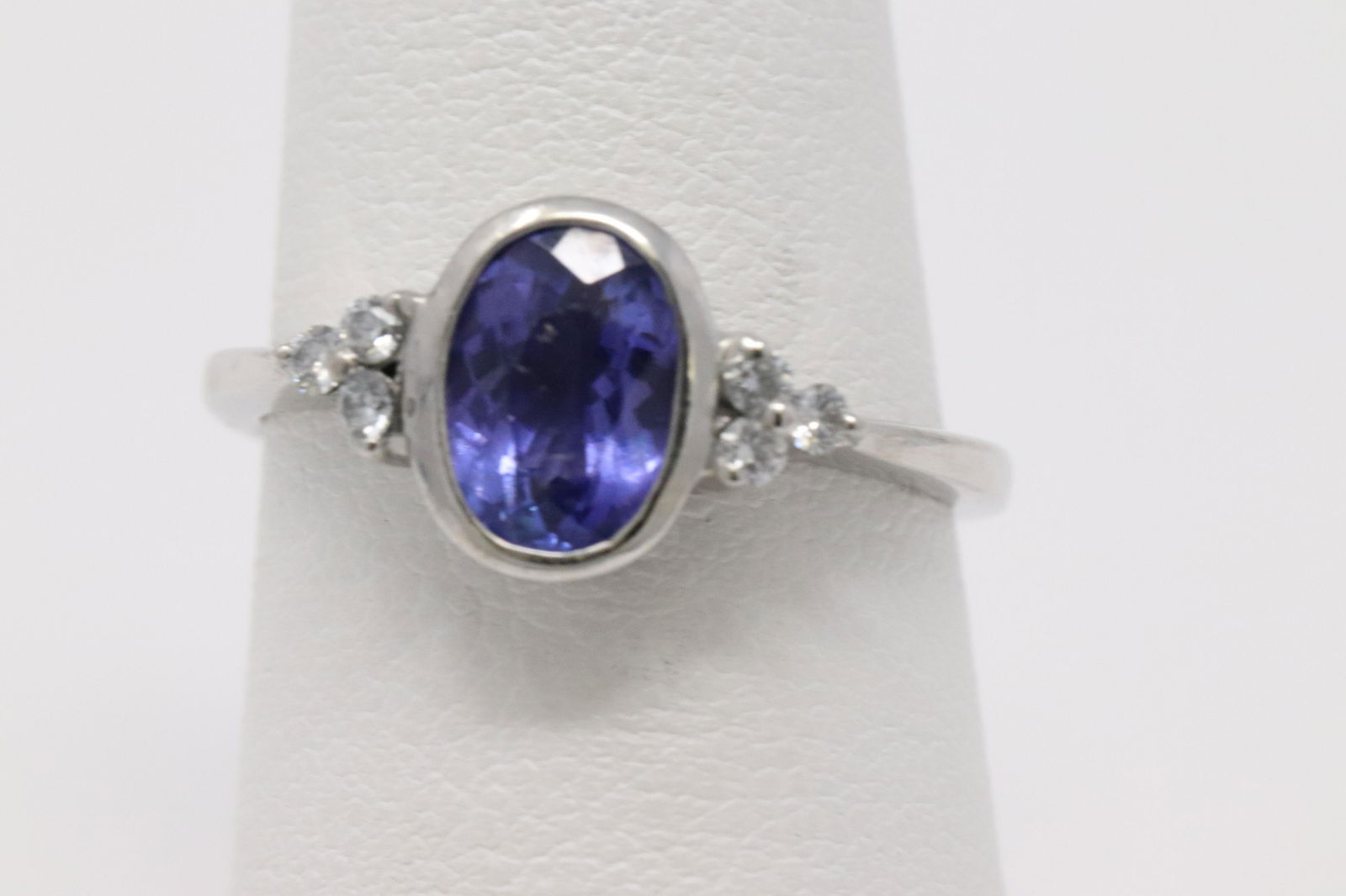14Kt Art Deco Sapphire W/ Diamonds Ring: A Ladies 14kt White Gold Art Deco Diamond Ring. The ring has a total of 6 round diamonds set on the sides of the ring. The center Blue Sapphire stone measures: 8.00x6.00mm. Ring size: 7.00. Total weig