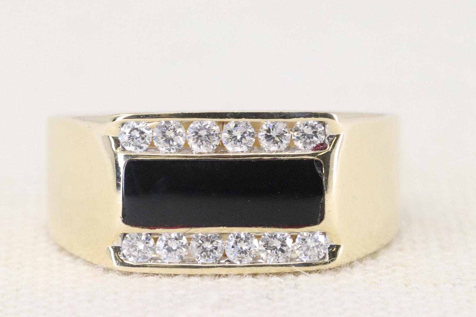 14Kt Men's Diamond & Oynx Ring: A Men's 14Kt Yellow Gold Diamond ring. The ring has a total of 12 round brilliant diamonds and a Recangular Black Onyx stone in the center. The diamonds are VS-SI clarity, weighting approx 0.75cttw. R