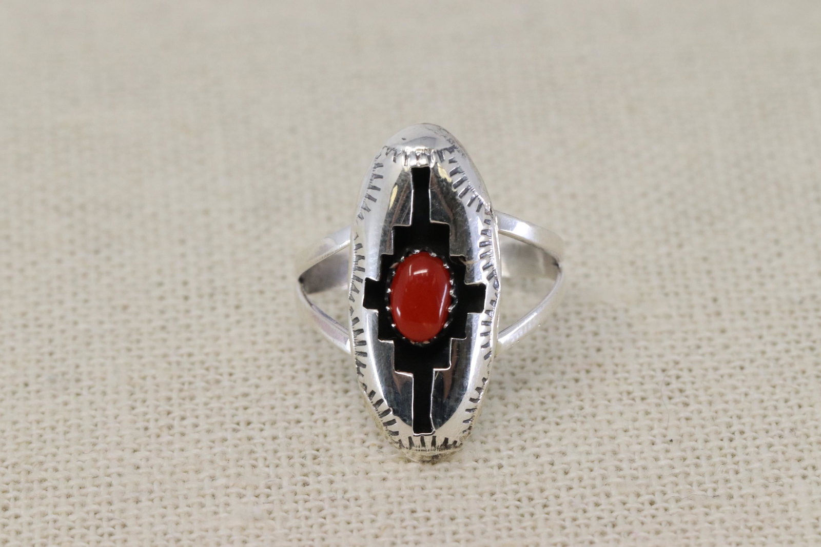 Navajo sterling silver coral Ring.: This sterling silver stamped shadowbox ladies ring has one 4X6mm natural coral stone. It measures just under 1" long by 7/16" wide on a split shank. It is Navajo hand made by Felix Perry. Ring size is