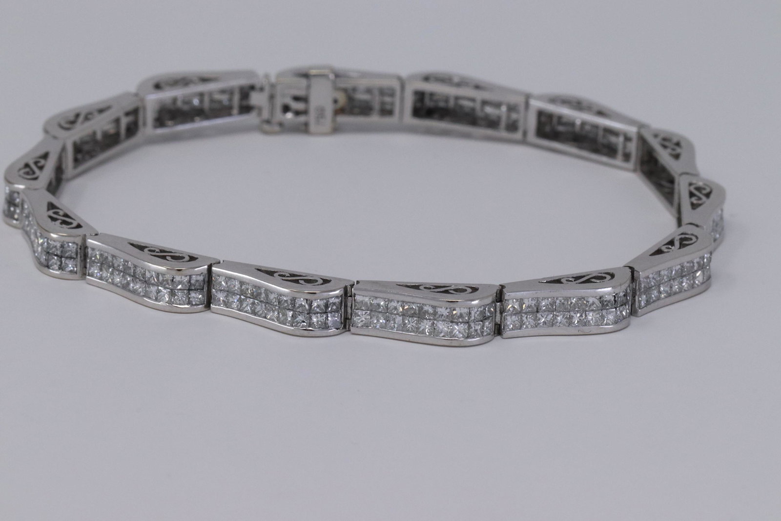 18Kt 7.50ctw Diamond Bracelet: A 18kt White Gold Diamond Bracelet. The bracelet has a total of 252 Princess Cut diamonds. The diamonds weight approx 7.50cttw.Diamonds clarity are VS-SI, F-G color. The bracelet workes for men or wom
