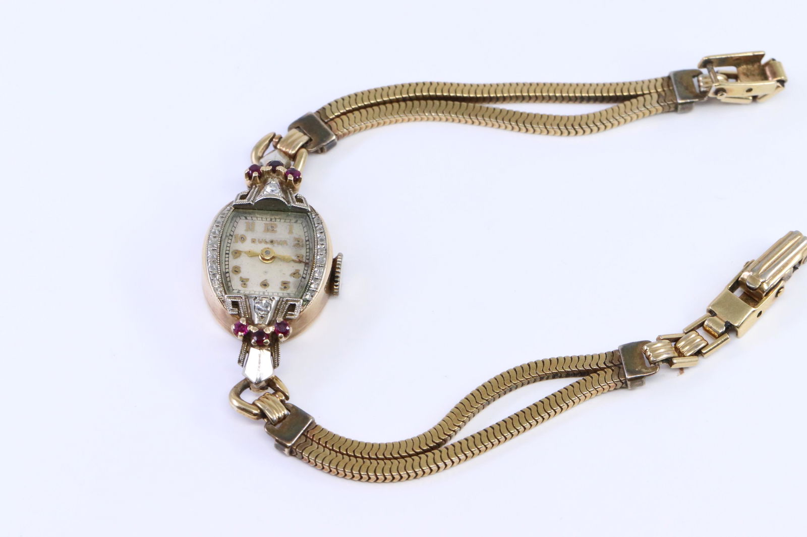 Vintage Bulova 14Kt Diamond Watch: A ladies 14kt Vintage Yellow Gold Diamond Bulova Watch. Watch has a total of 2 round diamonds and 6 round Ruby's. Case: 14kt Yellow Gold. Band: Gold-Filled.