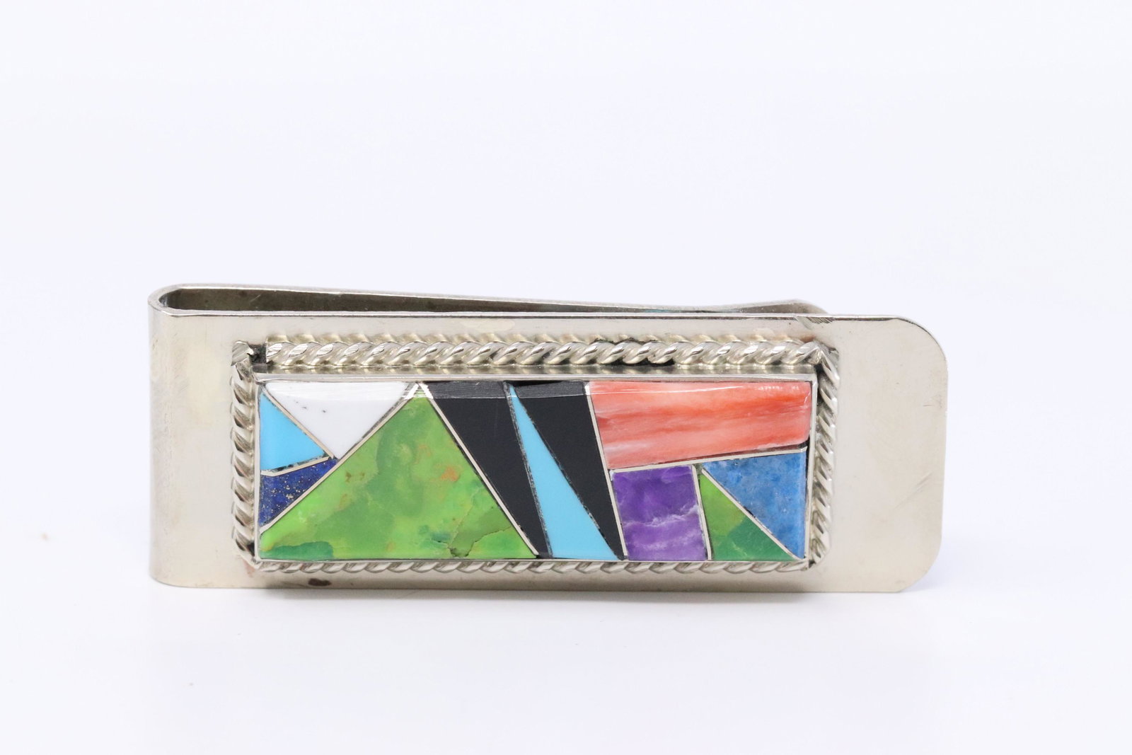 Money Clip Navajo inlaid in sterling silver: This is a Navajo inlaid in sterling silver bezel that has a twist wire border, set on a nickle 3/4" wide money clip. The inlay patterns and colors will vary. Inlaid by Arnold Yazzie.