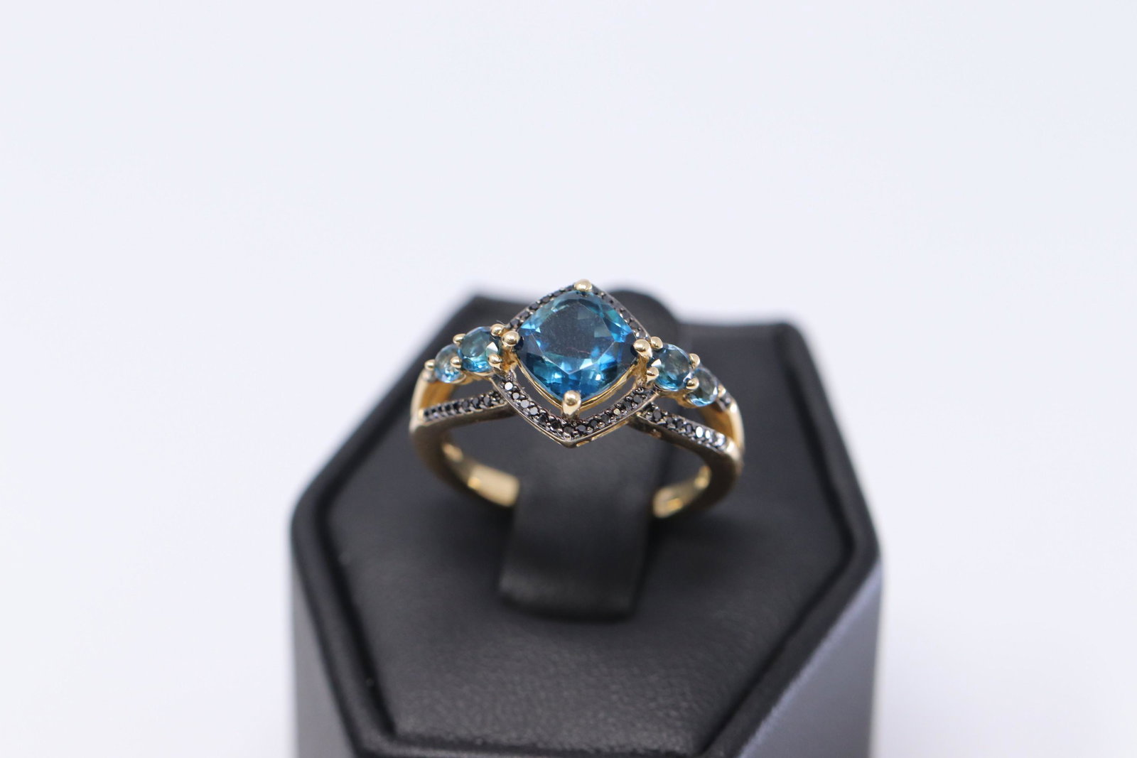14Kt Yellow Gold / Black Diamonds and Blue Topaz Ladies: A ladies 14kt Yellow Gold Black diamond ring. Ring has Blue topaz stones on the center and on the sides. Ring has also black diamonds set around the center stones and on the sides. Diamonds weight app