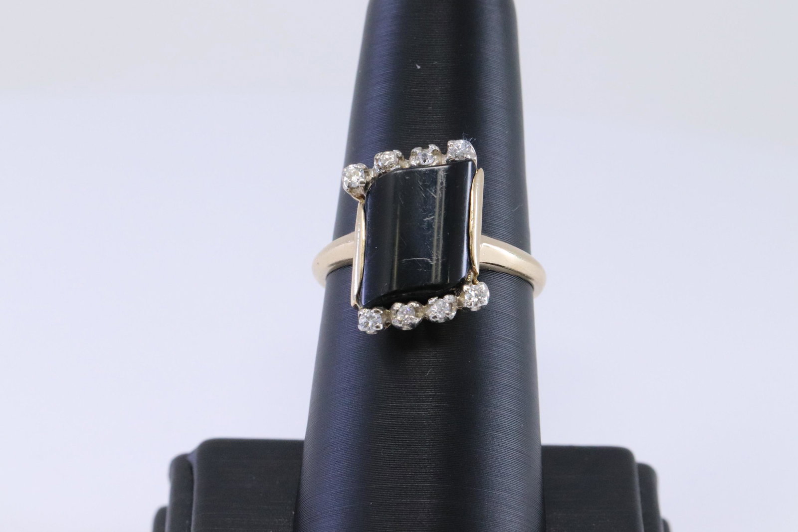 Ladies Diamond | Onyx Ring: A ladies Yellow Gold Diamond ring with Black Onyx stone in the center. There are total of 8 round brilliant diamonds weighting approx 0.25cttw. Ring size: 8.75. Total weight: 4.10 grams.