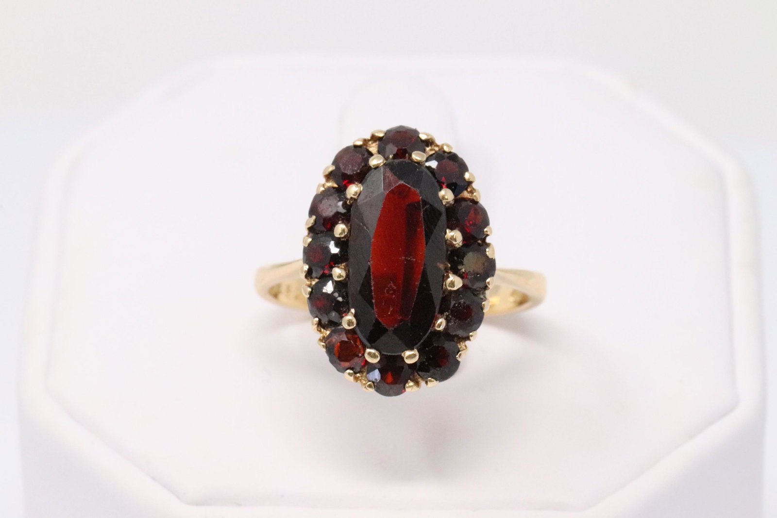 18KT Vintage Garnet Ring: A ladies 18KT Yellow Gold Vintage Garnet ring. Ring has a total of 12 round Garnets and a Oval shape Garnet stone in the center. Stones may have small scratches due to age. Ring size: 8.50. Total weig