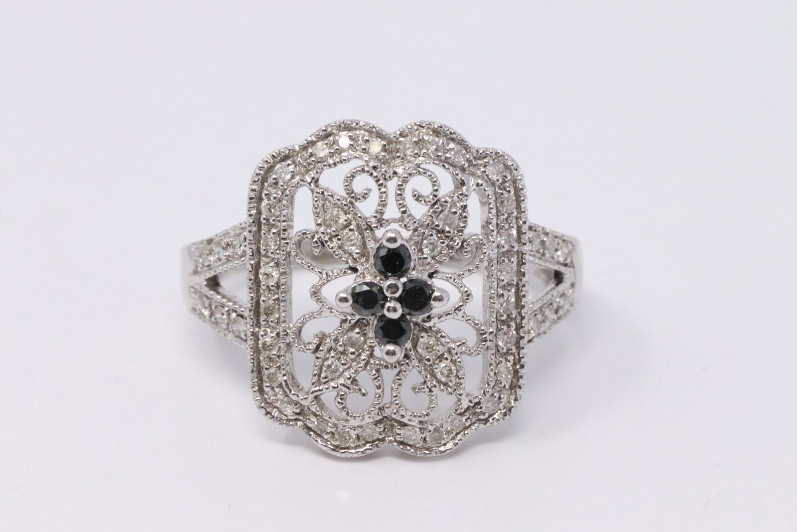 14Kt White Gold Diamond Ring: A ladies 14kt White Gold Diamond ring. Ring has 4 black diamonds in the center and round diamonds on the sides. Diamonds weight 0.33cttw. Ring size: 6.25. Total weight: 4.30 grams. #AY