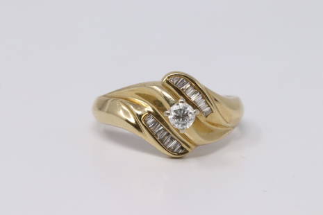14KT Ladies Diamond Ring: A ladies 14KT Yellow Gold Diamond ring. Ring has a Round brilliant diamond in the center and Baguette cut diamonds on the sides. Total diamond weight approx: 0.35cttw. Ring size: 5.00. Total weight