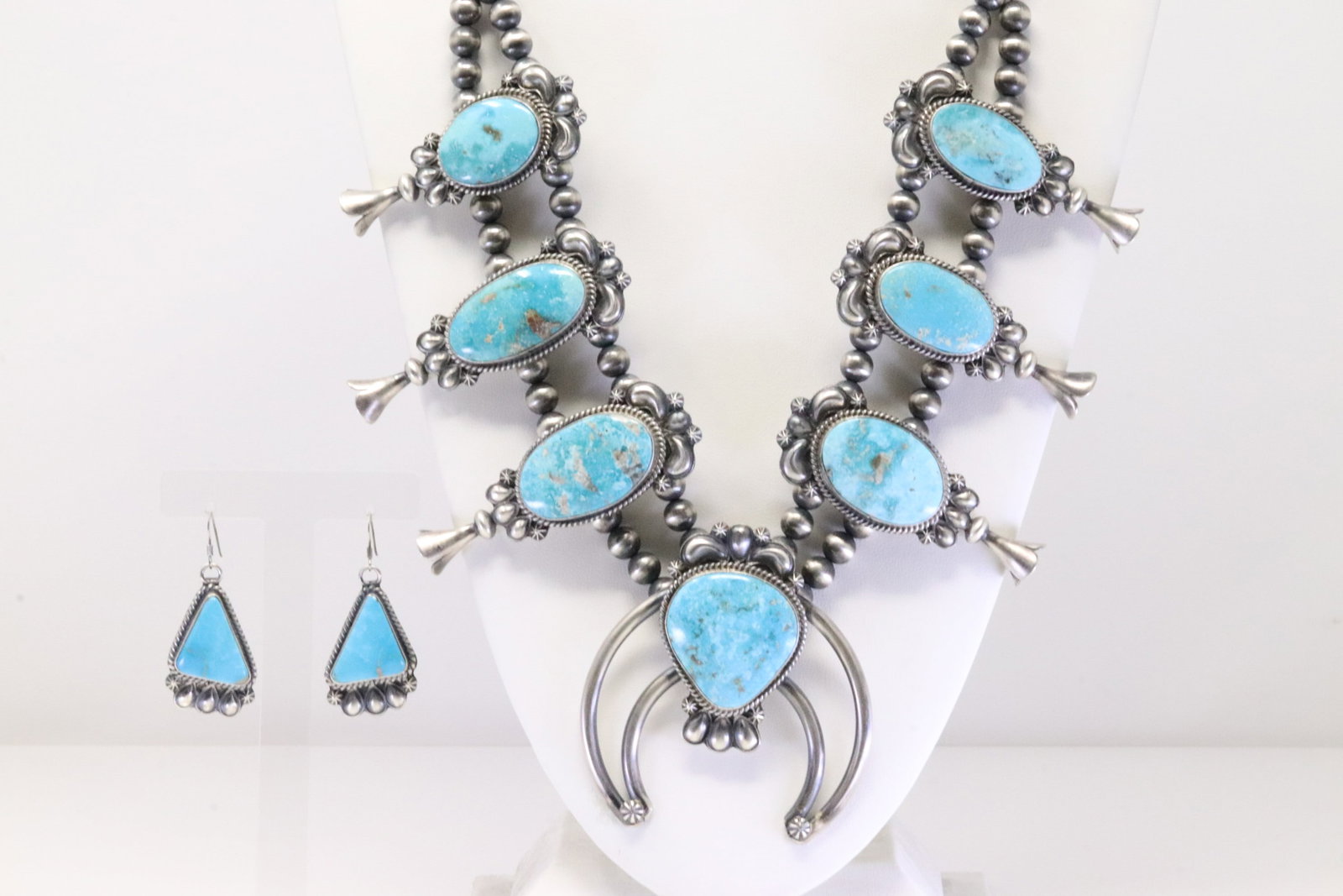 Native America Navajo Sterling Silver Kingman Turquoise Squash Blossom Necklace & Earring's Set By: This is a Native America Navajo Sterling Silver Kingman Turquoise Squash Blossom Necklace & Earring's Set By Ray Delgarito. Necklace length: 26.00" Total weight: 198.00 Grams.