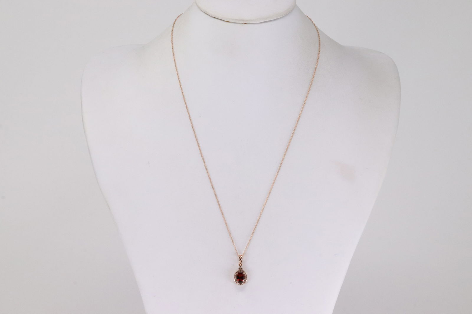 Sapphire & Garnet Necklace 10Kt.: Ladies 10Kt Rose Gold Sapphire & garnet Necklace. This Necklace has Charm with White round Sapphire and Oval Garnet. Necklace lengthg: 18.00"