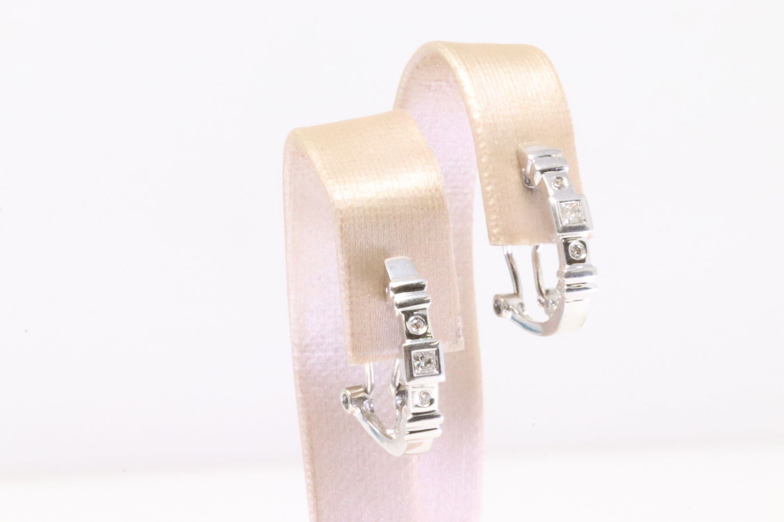 Diamond Huggie Earring 14Kt.: Ladies 14Kt White Gold Diamond Huggie Earring. Earring's has 4 round & 2 Cut Square Diamonds With French Backing Style. Diamonds weight approx: 0.20ctw. Total weight: 4.20 Grams.