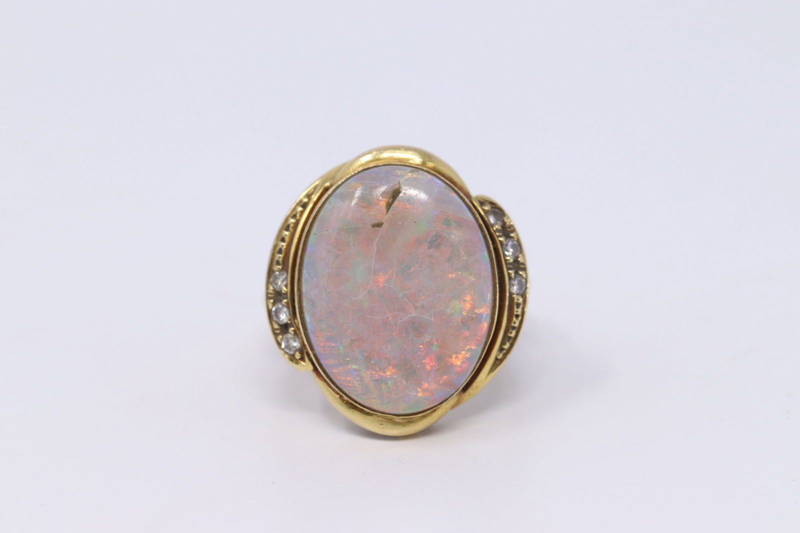 18Kt Art Deco Opal-Diamond Ladies Ring: A ladies 18kt Yellow Gold Art Deco Diamond & Opal Ring. Opal stone measures: 19.64x15.06mm. Total of 6 round diamonds set on the sides. Opal hasa small chip towards the bottom. Markings( 18k 75%).