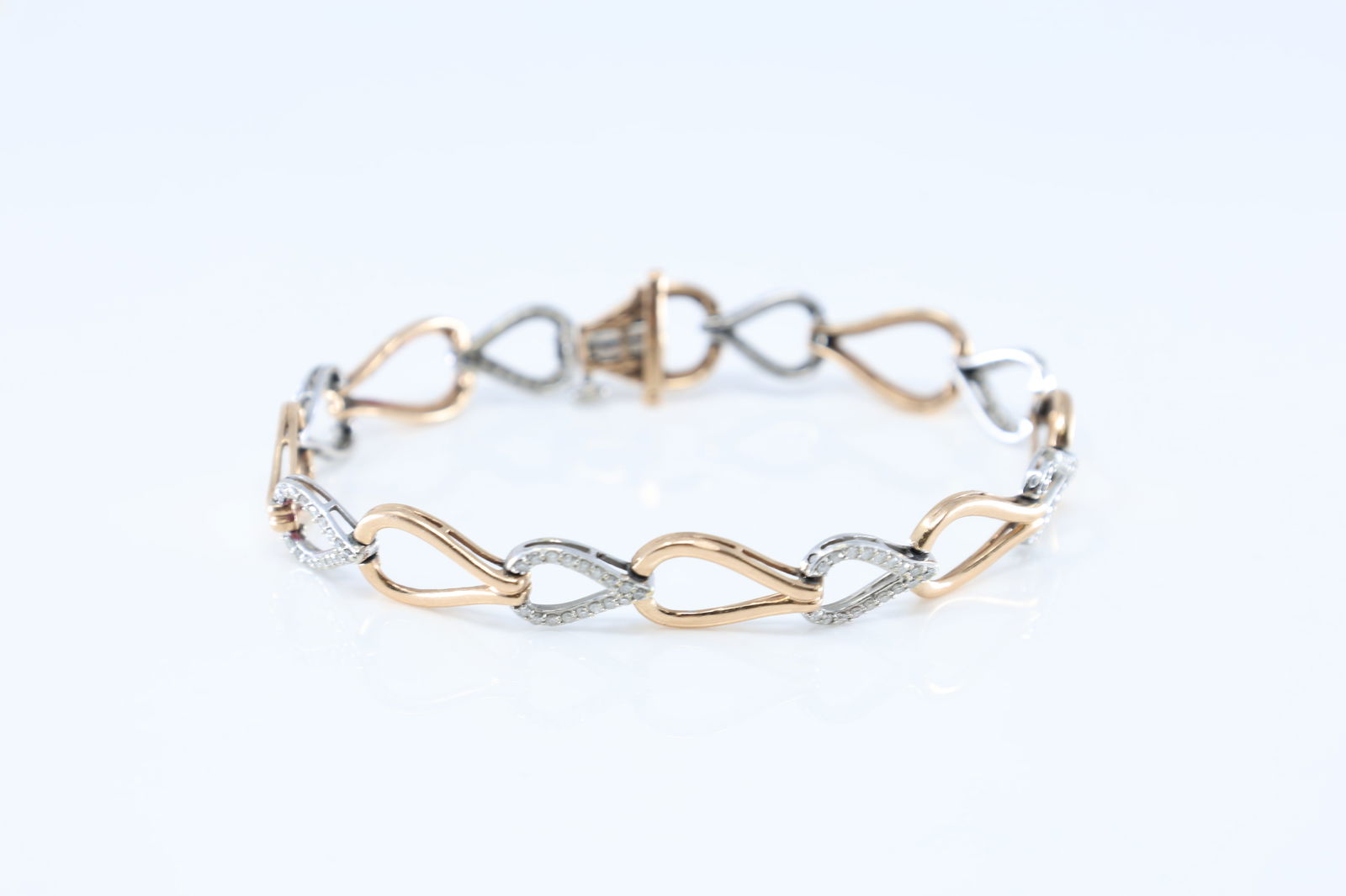 Two-tone Diamond Heart Bracelet .: 10Kt Rose Gold Diamond Heart Bracelet. This bracelet has 2 tone white / rose gold & a heart design with 136 sparkling round diamonds. Diamodns weight approx: 2.00ctw. Bracelet length: 8.00" Total