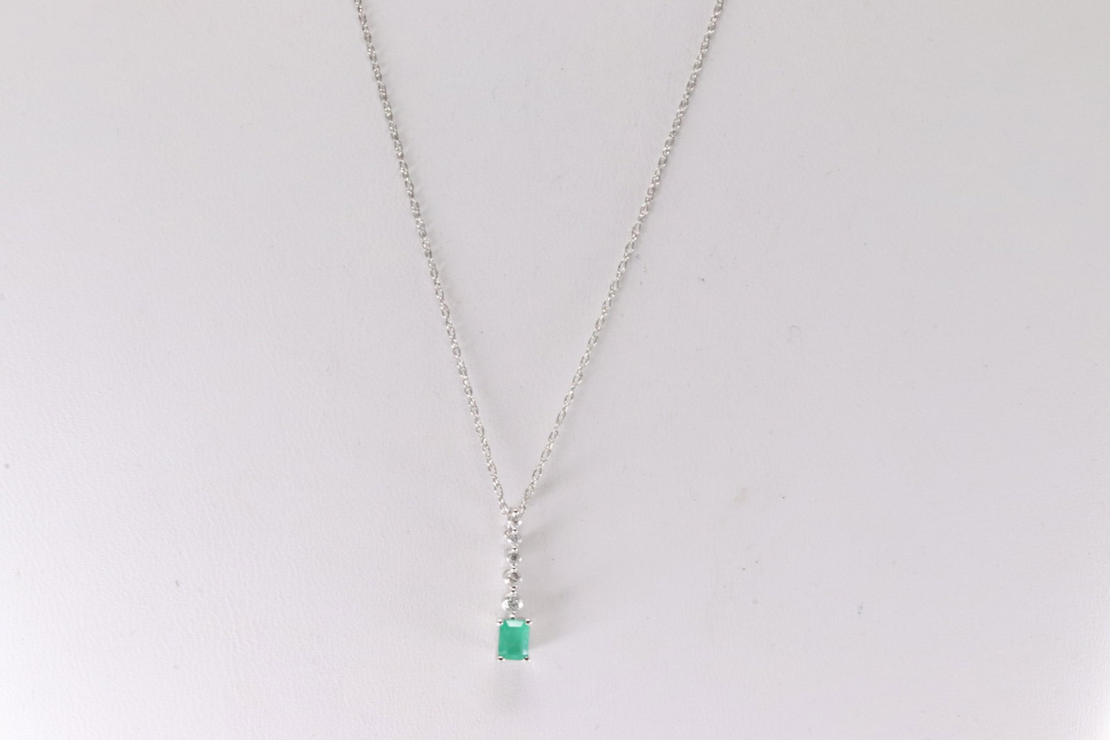 Emerald & Diamond Necklace 14Kt.: Ladies 14Kt White Gold Emerald & Diamond Necklace. Necklace has An Charm with Green Emerald & Round Diamonds. Diamonds weight: 0.07ctw. Emerald weight: 0.22ct. Necklace length: 18.00"