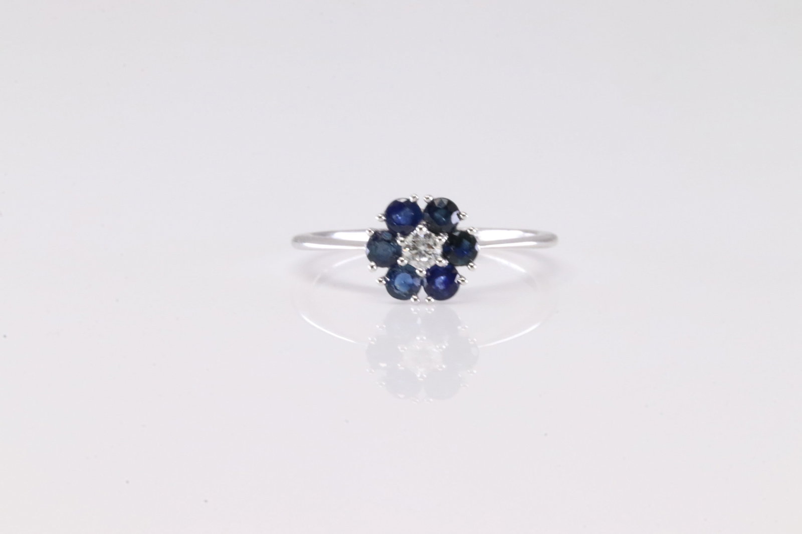 Sapphire & Diamond Ring 10Kt.: 10Kt White Gold Sapphire & Diamond Ring. This Charming Ring has Flower Design with Sapphires and one Diamond. Ring size: 6.50.