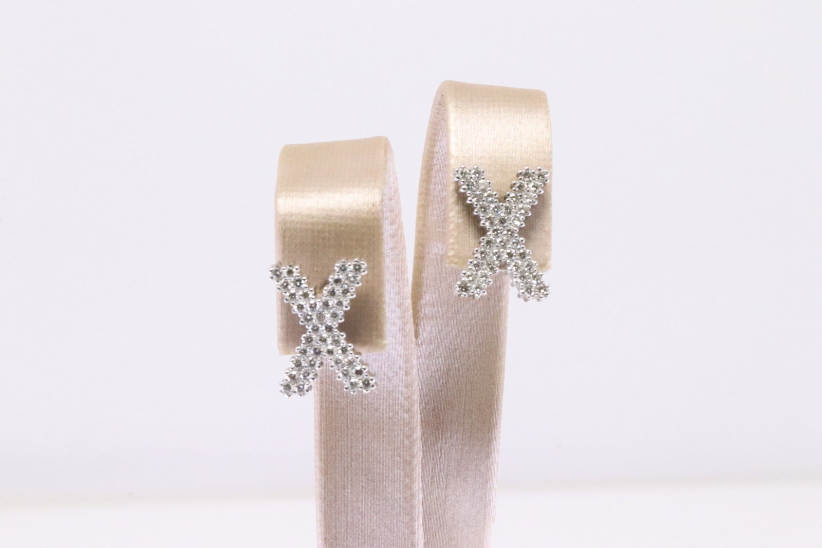 Diamond X Stud Earring 18Kt.: 18Kt White Gold Diamond X Stud Earring. These stunning diamond earrings feature a unique 'X' design, crafted to perfection. Each earring is encrusted with 80 sparkling diamonds that catch the light