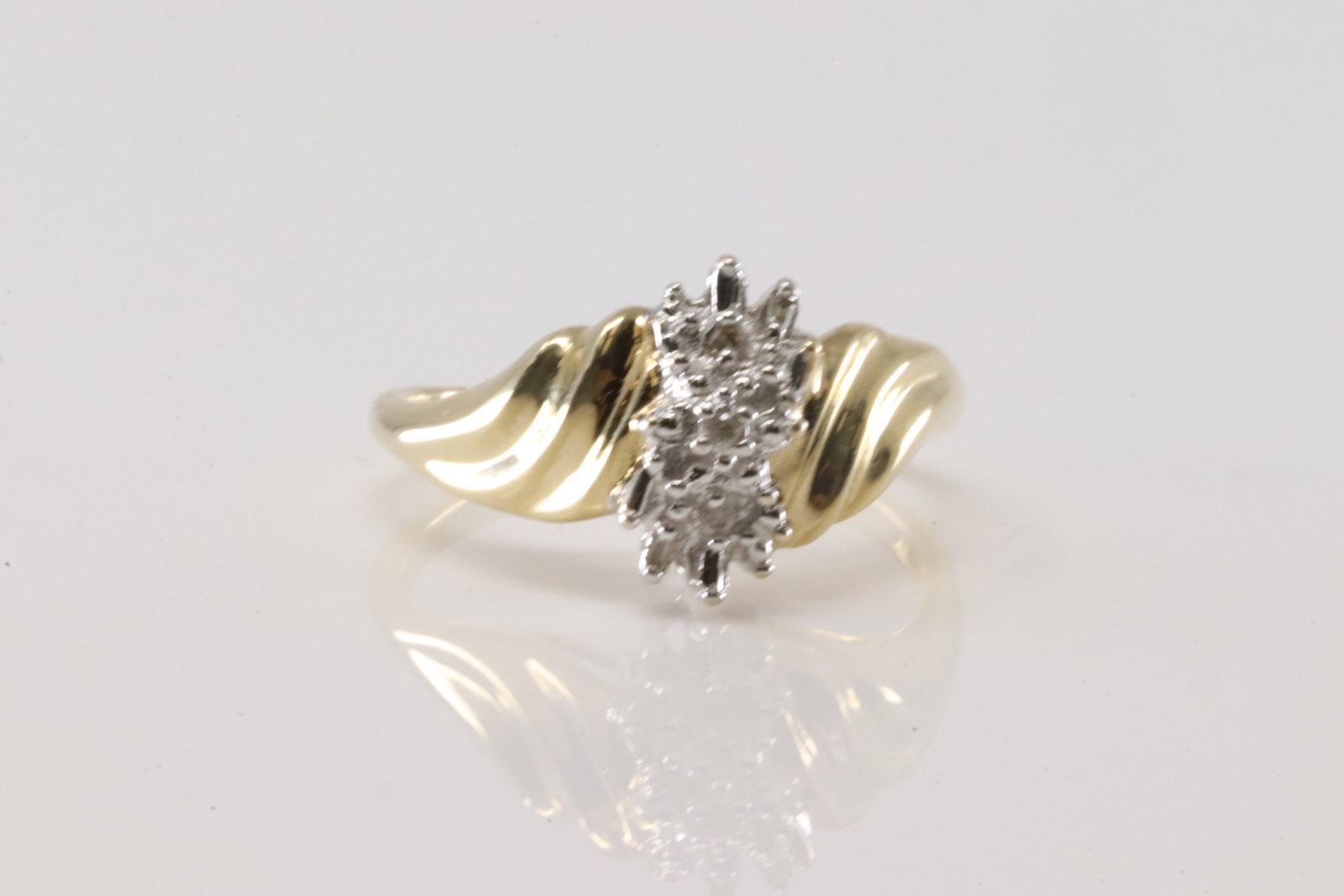 Diamond Ring 10Kt.: Ladies 10Kt Yellow Gold Diamond Ring. Ring has two tone gold with 3 smaller round diamonds & 4 baguette cut. Ring size: 7.25. Total weight: 2.70 Grams.