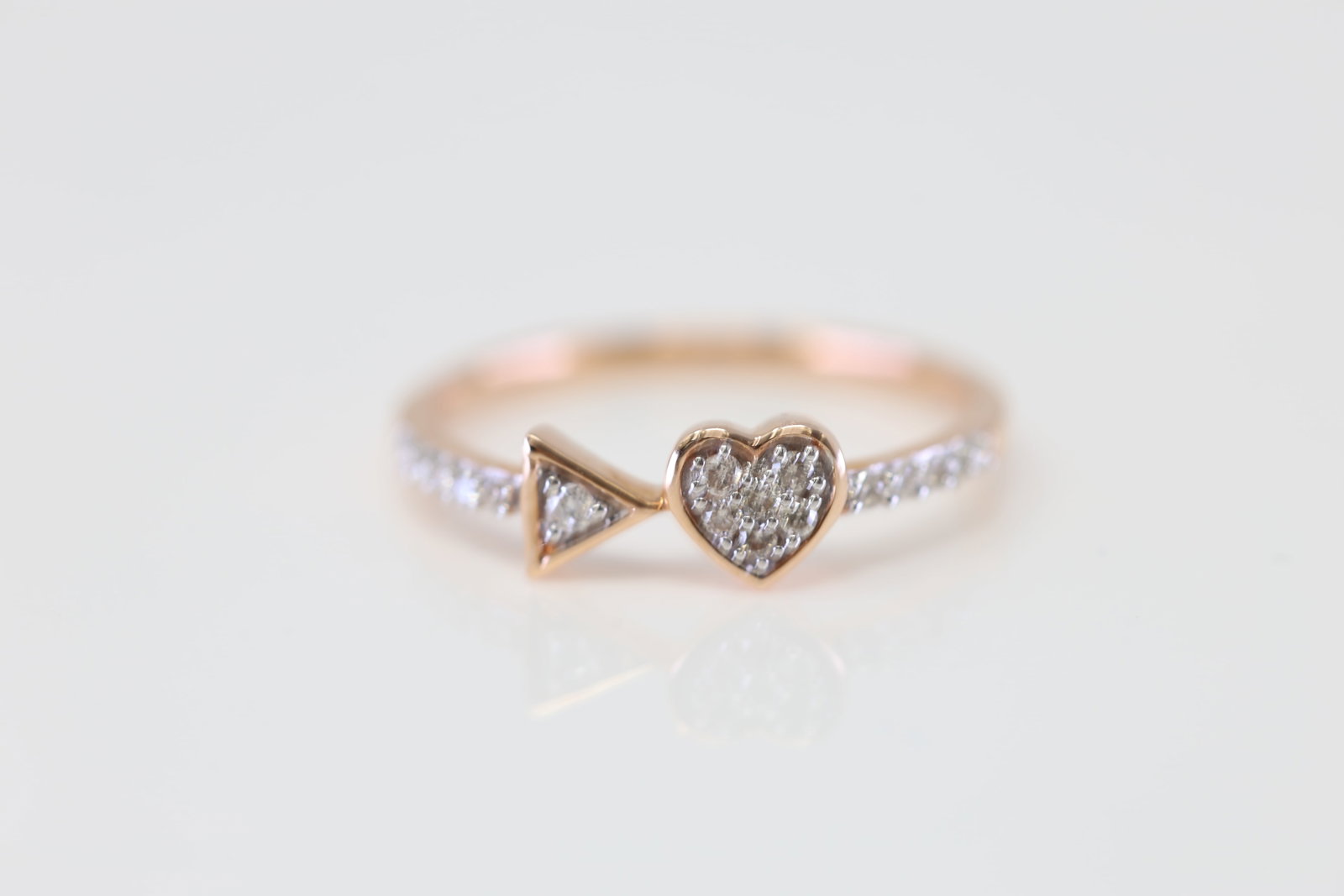 Heart and Triangle Diamond Ring 10Kt.: Ladies 10Kt Rose Gold Heart and Triangle Diamond Ring. This exquisite ring features a delicate balance of elegance and modern design. The band is adorned with sparkling diamonds, leading to two captiv