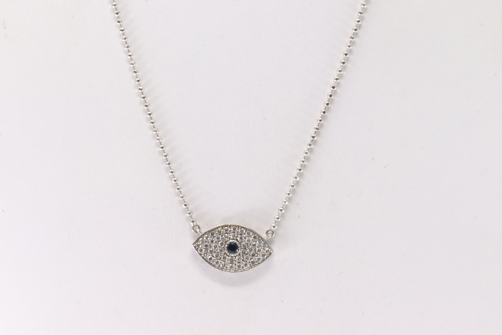 Evil Eye Sapphire & Diamond Necklace 14Kt.: 14Kt White Gold Evil Eye Sapphire & Diamond Necklace. This beautiful necklace has evil eye charm with blue sapphire and 46 sparkling diamonds. Diamonds weight approx: 1.00ctw. Necklace length: 18.00"