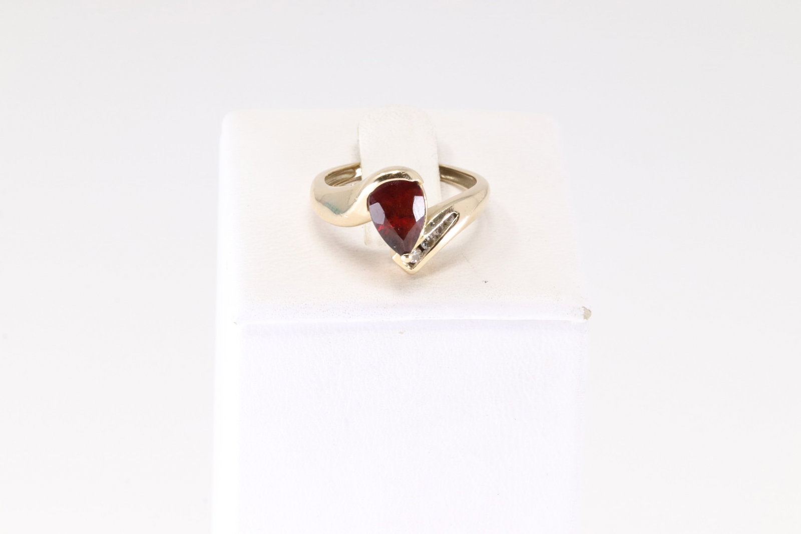 Garnet & Diamond Ring 14Kt.: Ladies 14Kt Yellow Gold Garnet & Diamond Ring. This Ring has Pear Shaped Garnet Gemstone With 4 Round Sparkling Diamonds. Diamonds Approx Weight: 0.20CTW. Ring Size: 6.00. Total Weight: 3.63 Grams.