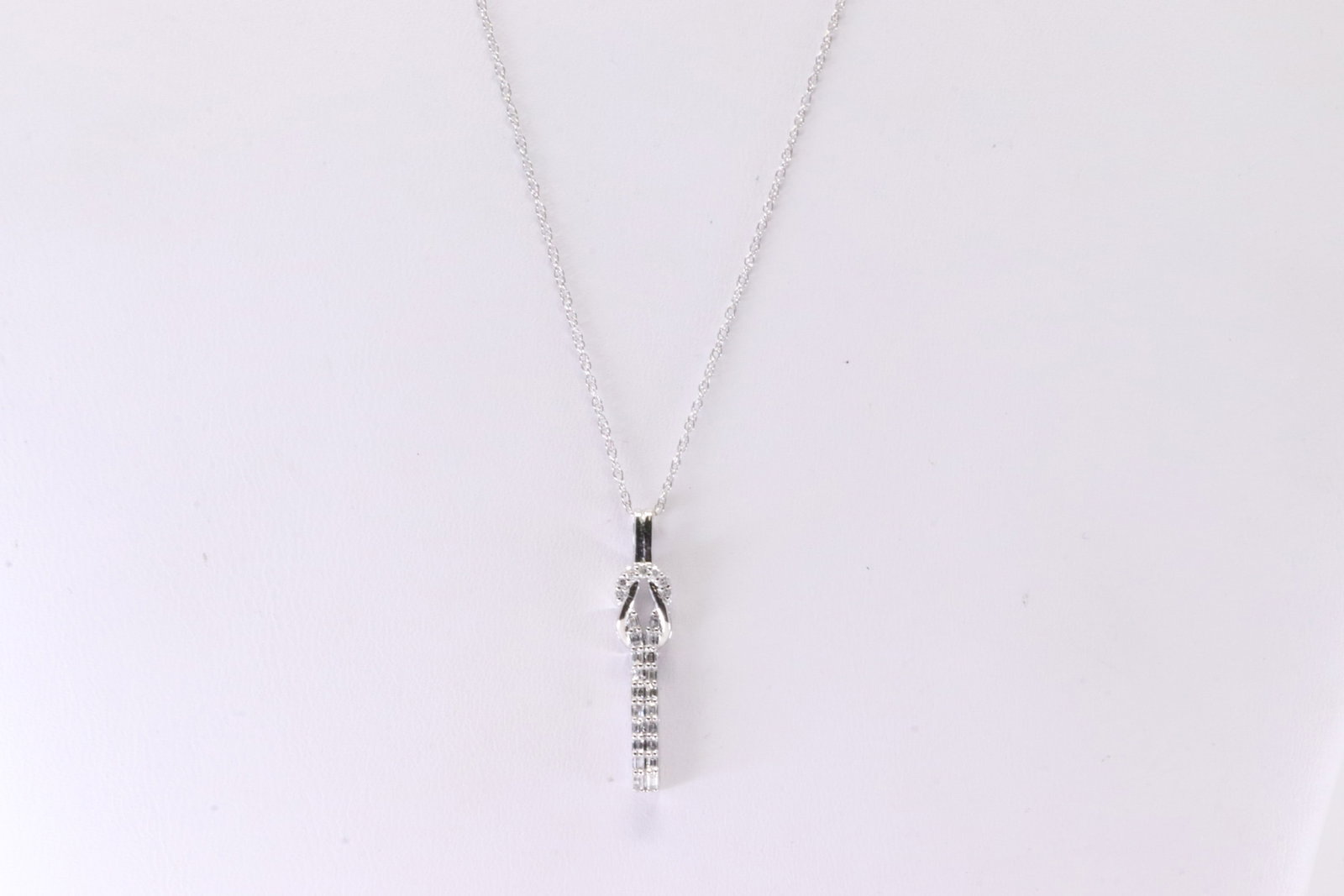 Diamond Pendant / Necklace 10KT.: Ladies 10Kt White Gold Diamond Pendant / Necklace. This Necklace has A Pendant With 7 Round Sparkling Diamonds & 20 Baguette Diamonds. Diamond Approx Weight: 0.18ctw. Necklace Length: 18.00.