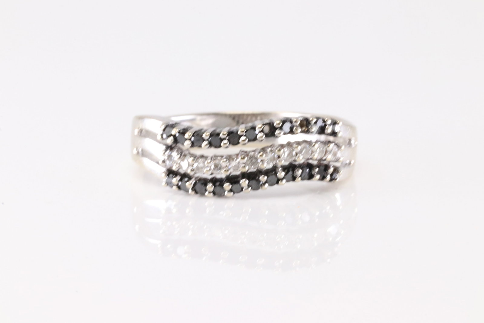 Black & White Diamond Ring 18Kt.: Ladies 18Kt Black & White Diamond Ring. This Elegant Ring has 22 Black Gemstones & 11 Round Sparkling Diamonds. Diamond Weight Approx: 1.00cttw. Ring Size: 8.00. Total Weight: 2.80 Grams.