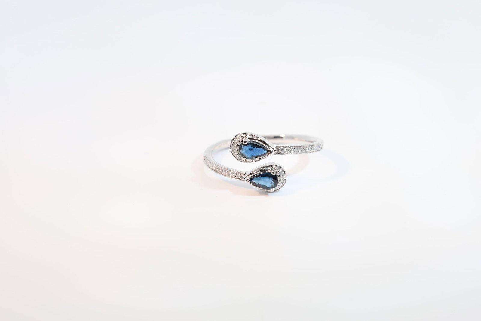 Sapphire & Diamond Ring 14Kt.: Ladies 14Kt White Gold Sapphire & Diamond Ring. Ring has 2 Pear Shaped Sapphire Gems with 32 round Diamonds. Diamonds weight: 0.10ct. Sapphire's weight: 0.43ct. Ring size: 7.00.