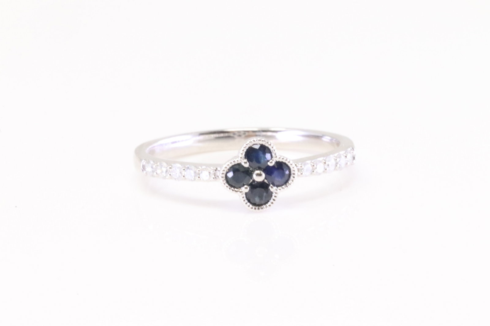 Sapphire & Diamond Ring 14Kt.: Ladies 14Kt White Gold Sapphire & Diamond Ring. Ring has Flower Design with 4 Sapphire's & 10 round Diamonds. Diamonds weight: 0.15ct. Ring size: 6.25. Total weight: 2.00 Grams.