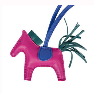 Hermes Rodeo PM Bag Charm in Rose Pourpre, Electric: Hermes Rodeo PM Agneau bag charm in vivid pink Pourpre, Electric Blue saddle with Malachite tail and mane. Crafted in Milo lambskin. Signature "HERMES PARIS MADE IN FRANCE" is stamped beneath the sadd