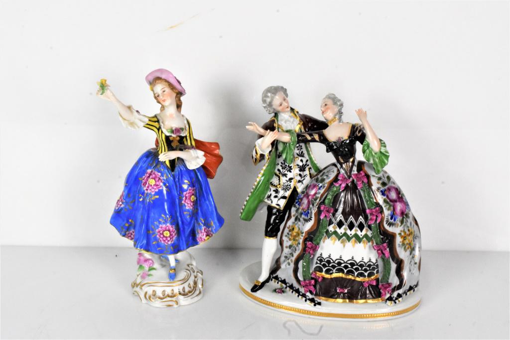 Porcelain Figurine Grouping: Grouping includes (2) pieces; a porcelain figurine of a young girl and a figurine depicting a nobleman and noblewoman dancing. The young girl is in beautiful condition with a minor chip on the cape an