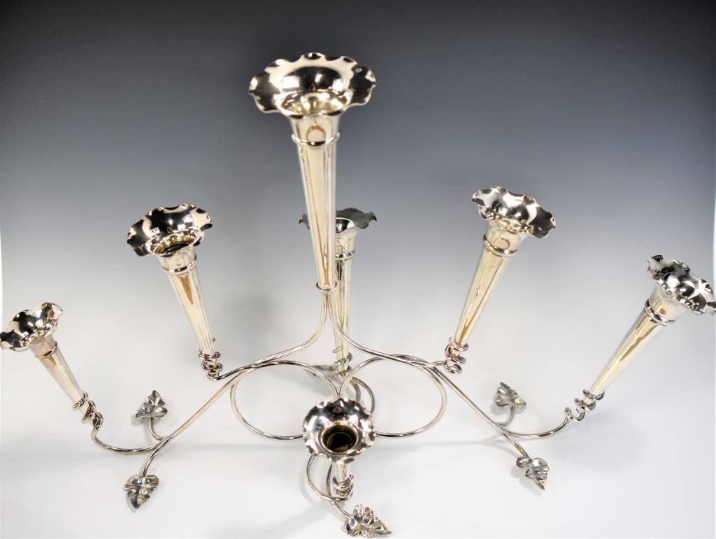 English Silverplate Epergne: Includes an lovely epergne with Angel's Trumpet flower and leaf design. Stamps on base were overstamped and are illegible; however, 344 Mad in England is visible. Measures approx. 16"h by 26"l by 12.5