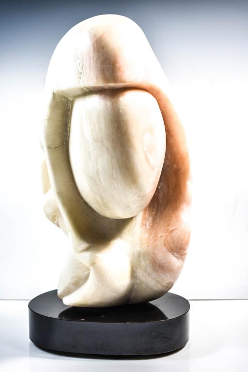 Modernist Figure of a Faceless Woman: Carved Alabaster or marble figure of the head of a faceless Woman on a black stone base. Mid century, circa 1960-1970. measures approx: 20"h Provenance: From a private collection in Abington, PA