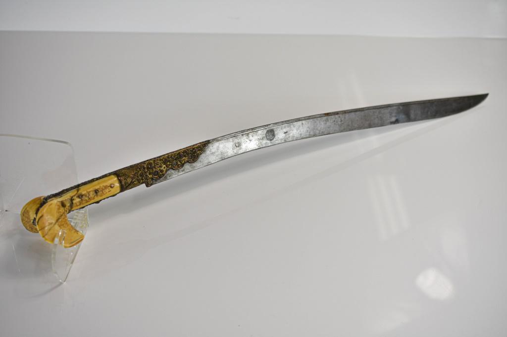 Antique Ottoman Yataghan: Includes an Ottoman yataghan. There are (2) rempairs to the hilt; (1) to the bone and (1) to the metal. Exceptionally ornate sword, blade has some etchings and has exquisite ornate brass fittings and 