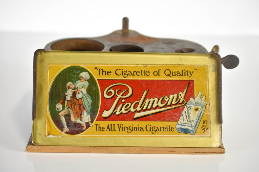 1912 Piedmont Cigar Cutter / Lighter Brunhuff Mfg.: Antique Cigar Store Display Stand Advertising Piece for Piedmont Cigarettes. Stamped metal shows wear as shown in Photos. Does not include Lamp or Hurricane. Marked " ' The Cigarette of Quality' The A