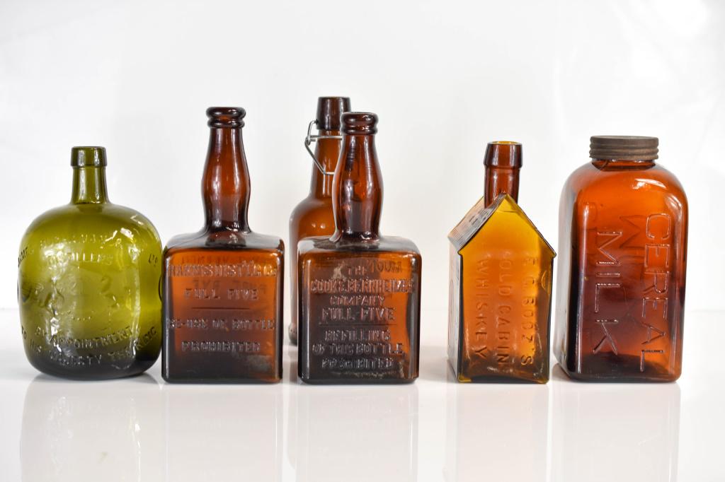 Antique Amber Glass Bottles: Grouping includes (6) pieces of antique amber glass including (1) cereal mil jar with original cap and early two thread screw cap design and (4) alcohol bottles including (3) whiskey bottles (one of w