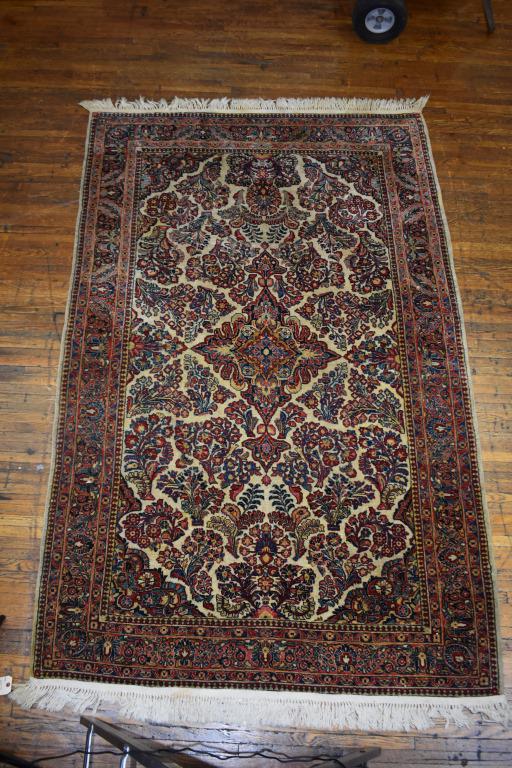 Antique Persian Sarouk Ferahan Ivory Ground Rug: Antique Persian Sarouk Ferahan with a central medallion, flower baskets with an allover design on a ivory, red and blue ground .and curvilinear corners. Low thin pile (not from wear). Fringe has been