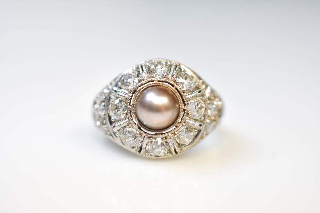 Early 19k Diamond And Black Pearl Dinner Ring: "19k" White Gold (tests At Least 18k) Containing A 5.5mm Black Pearl Surrounded By Eight Old Mine Cut Diamonds, Approx. 0.10 Ct Each, Flanked By 10 Old Mine Cut Diamonds, Approx. 0.04 Ct Each. Approx.