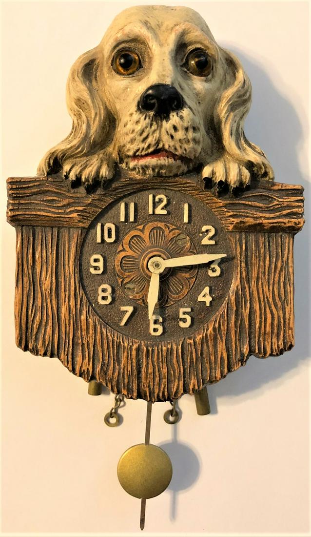 KEEBLER WHITE COCKER SPANIEL PENDULETTE CLOCK: KEEBLER WHITE COCKER SPANIEL W/ GLASS EYES, PEEKING OVER FENCE PENDULETTE WALL CLOCK - NO. 336 CIRCA 1931 - 3 3/4" X 6 3/4"